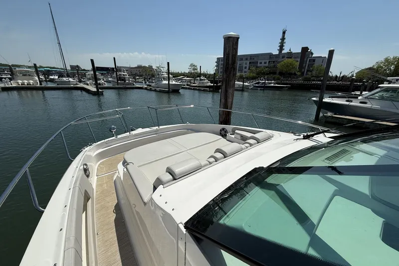 Slide: The Image of 2023 Sea Ray Sundancer 320 yacht docked at a marina, showcasing sleek design and spacious deck. - 23