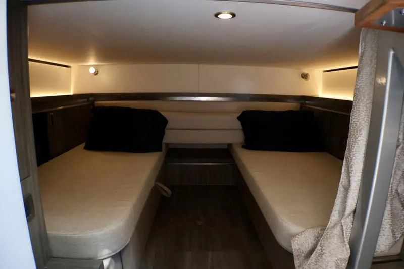 Slide: The Image of Interior cabin of 2023 Sea Ray Sundancer 320 with twin beds and ambient lighting. - 29