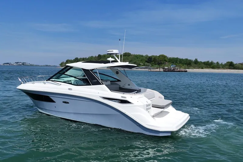 Slide: The Image of 2023 Sea Ray Sundancer 320 cruising on a sunny day near a scenic shoreline. - 4