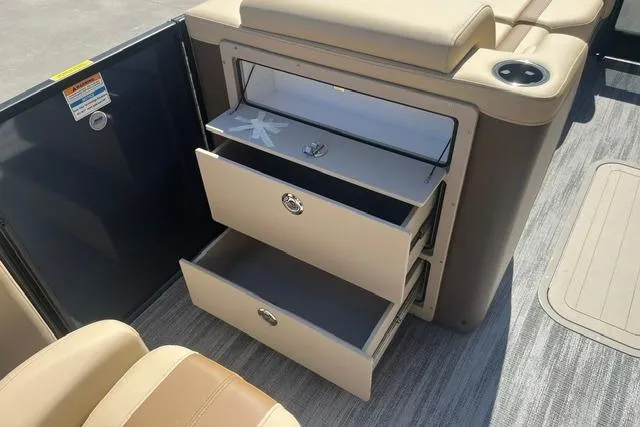 Slide: The Image of Interior storage drawers on 2026 Godfrey Monaco 235 SB boat, featuring beige upholstery. - 12