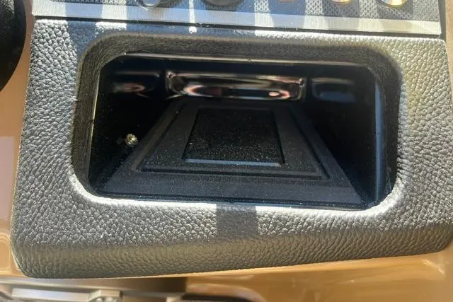 Slide: The Image of Dashboard compartment of 2026 Godfrey Monaco 235 SB boat, featuring textured black interior. - 18