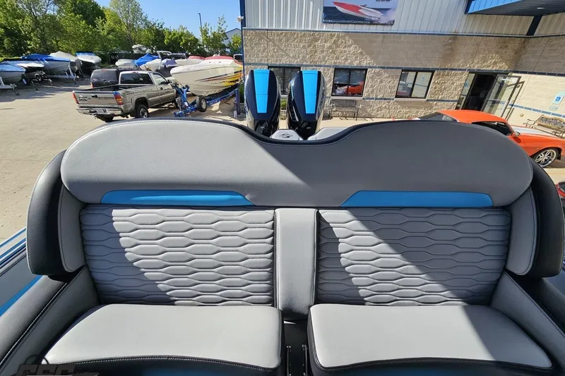 Slide: The Image of 2025 Sunsation 32 CCX boat interior with gray and blue seating, outdoor showroom. - 106