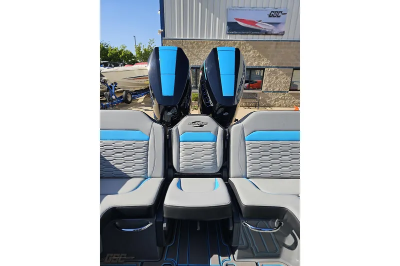 Slide: The Image of 2025 Sunsation 32 CCX boat interior with blue and gray seating, featuring dual outboard motors. - 110