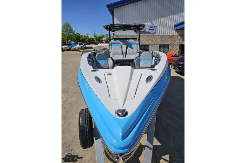 Slide: The Image of 2025 Sunsation 32 CCX boat with blue and white design, parked outdoors. - 18