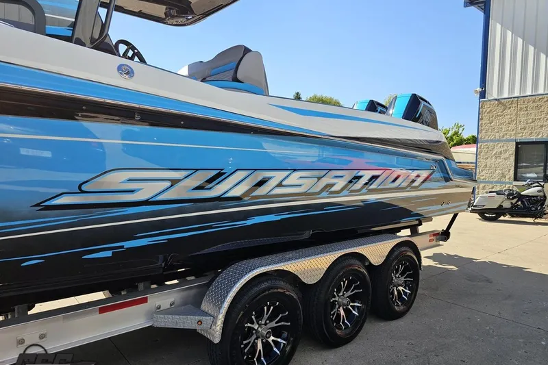 Slide: The Image of 2025 Sunsation 32 CCX boat on trailer, featuring sleek blue design and bold branding. - 25