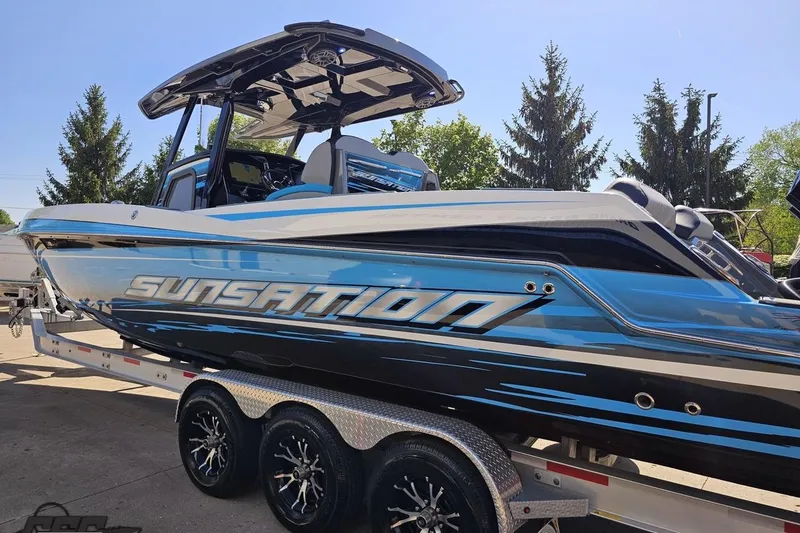 Slide: The Image of 2025 Sunsation 32 CCX boat on trailer, featuring sleek blue and black design. - 30