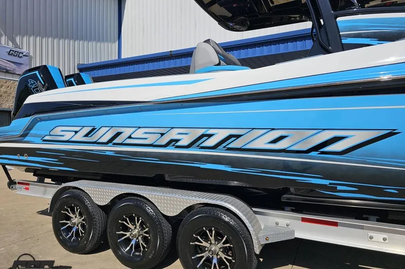 Slide: The Image of 2025 Sunsation 32 CCX boat in blue on a trailer, showcasing sleek design. - 6