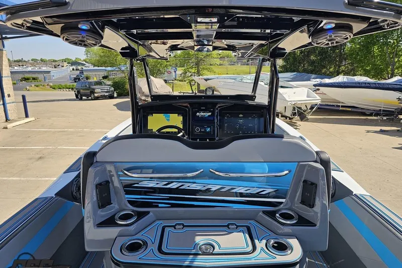 Slide: The Image of 2025 Sunsation 32 CCX boat interior with advanced dashboard and seating in a marina setting. - 63
