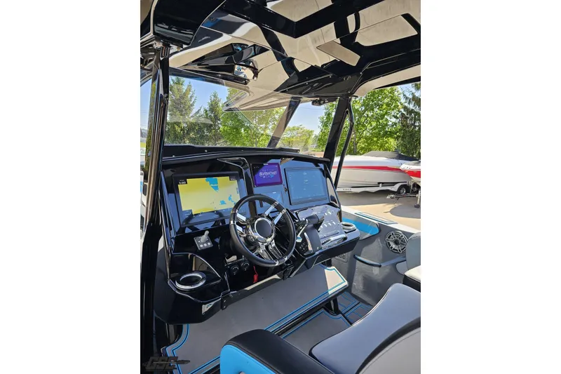 Slide: The Image of 2025 Sunsation 32 CCX boat cockpit with advanced navigation displays and sleek steering wheel. - 69