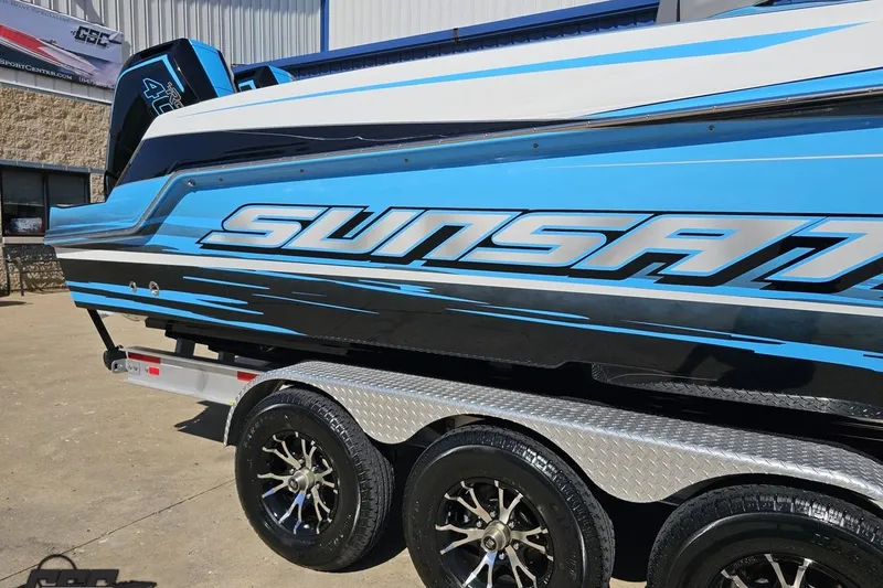 Slide: The Image of 2025 Sunsation 32 CCX boat in blue and black on a trailer, showcasing sleek design. - 7
