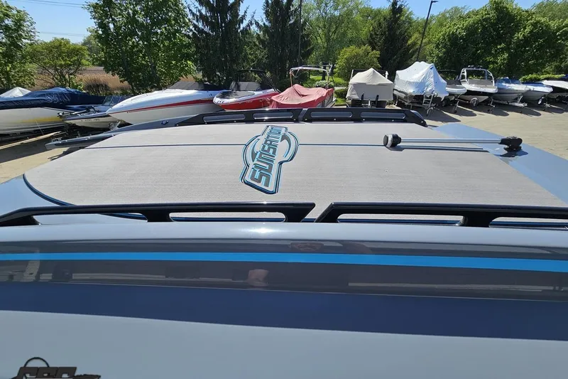 Slide: The Image of 2025 Sunsation 32 CCX boat with logo, parked among other covered boats. - 73