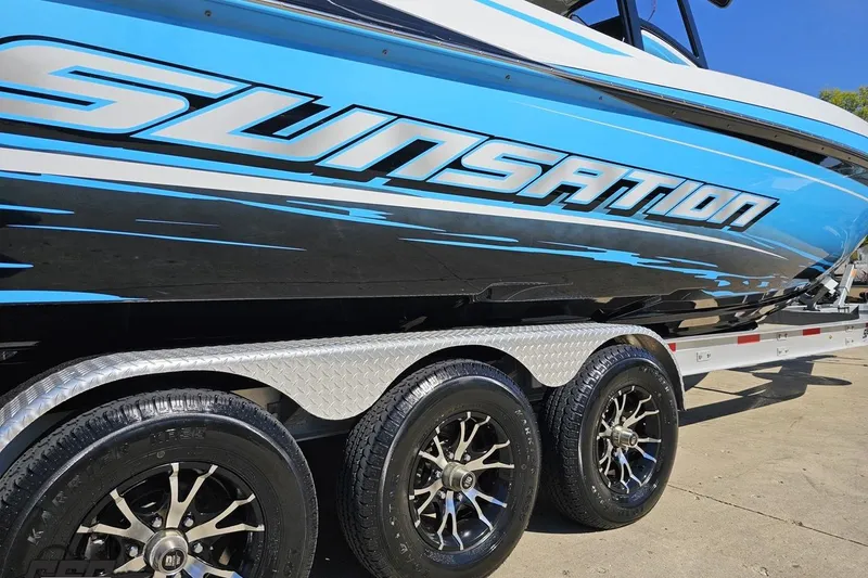 Slide: The Image of 2025 Sunsation 32 CCX boat on trailer, featuring sleek blue and black design. - 8