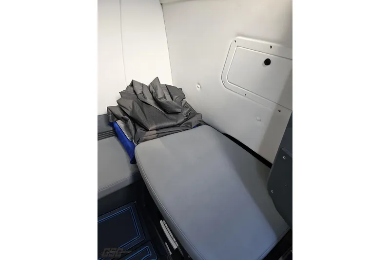 Slide: The Image of Interior cabin of 2025 Sunsation 32 CCX boat, featuring a cushioned seat and storage compartment. - 88
