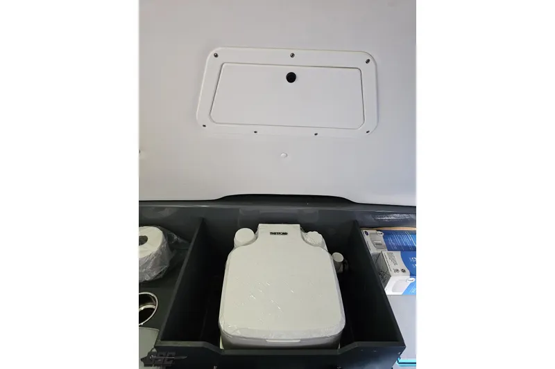 Slide: The Image of 2025 Sunsation 32 CCX boat interior storage compartment with portable toilet and supplies. - 89