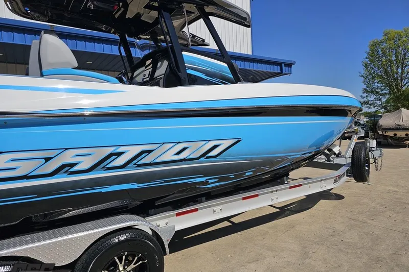 Slide: The Image of 2025 Sunsation 32 CCX boat in blue and white on a trailer, outdoors. - 9
