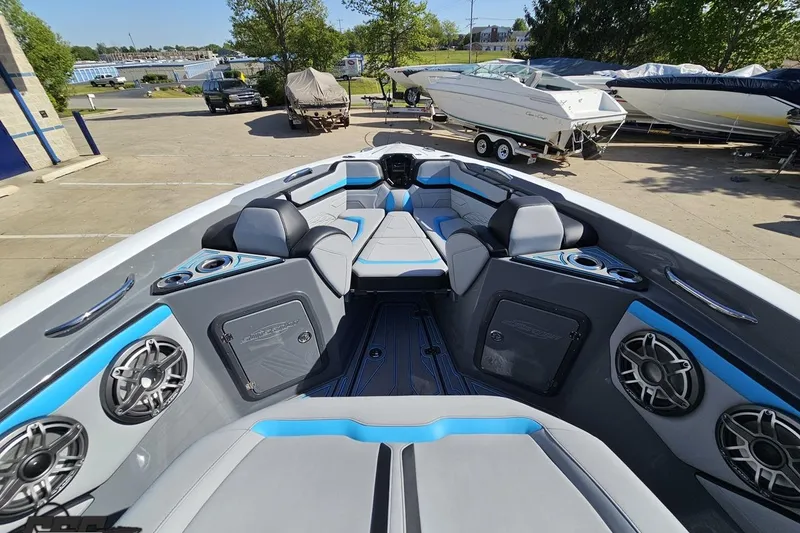 Slide: The Image of 2025 Sunsation 32 CCX boat interior with modern seating and audio system in a marina setting. - 93