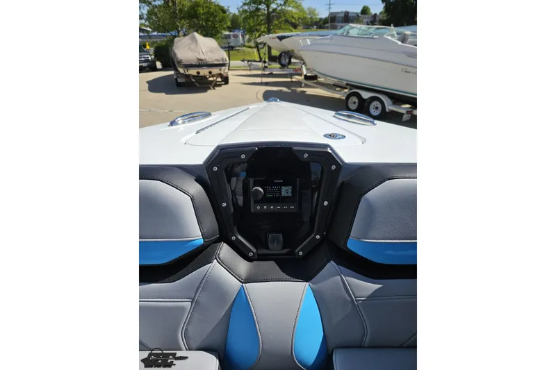 Slide: The Image of 2025 Sunsation 32 CCX boat interior with modern dashboard and seating, parked in a marina. - 99