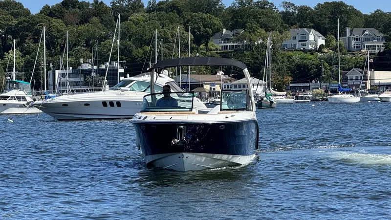 Slide: The Image of A 2027 Sea Ray SDX 270 Outboard cruising on calm waters with other boats in the background. - 2
