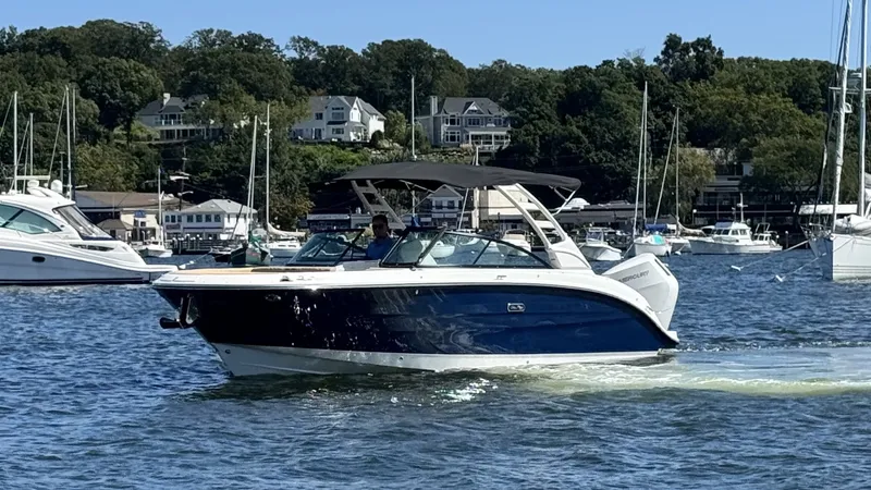 Slide: The Image of A 2027 Sea Ray SDX 270 Outboard cruising on calm waters, surrounded by other boats. - 26