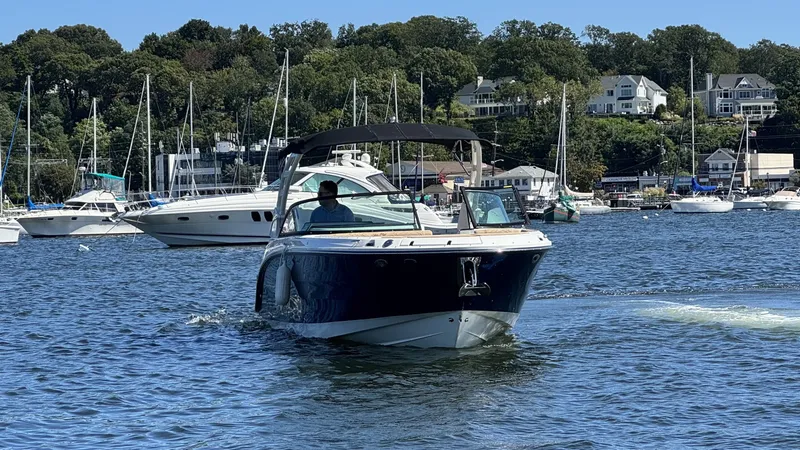 Slide: The Image of A 2027 Sea Ray SDX 270 Outboard cruising on calm waters with other boats in the background. - 27