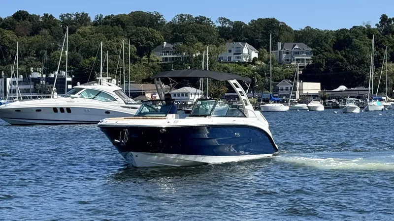 Slide: The Image of A 2027 Sea Ray SDX 270 Outboard cruising on calm waters with other boats in the background. - 1