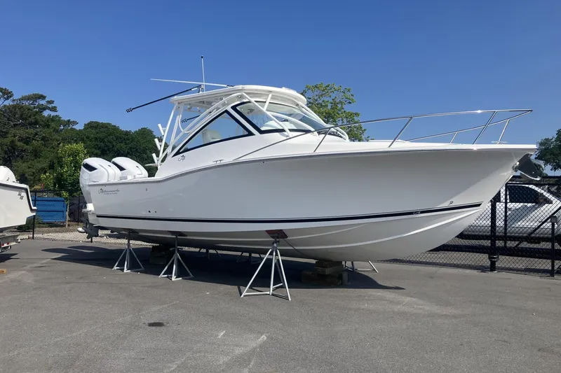 The Image of 2024 Albemarle 30 Express boat on stands, white hull, dual engines, clear sky background. - 1
