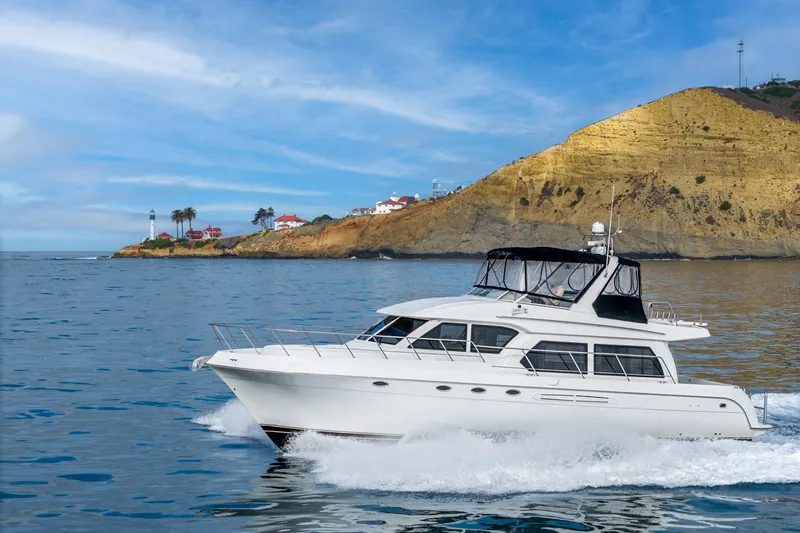 The Image of 2006 Navigator 5100 yacht cruising near scenic coastal cliffs and lighthouse. - 0