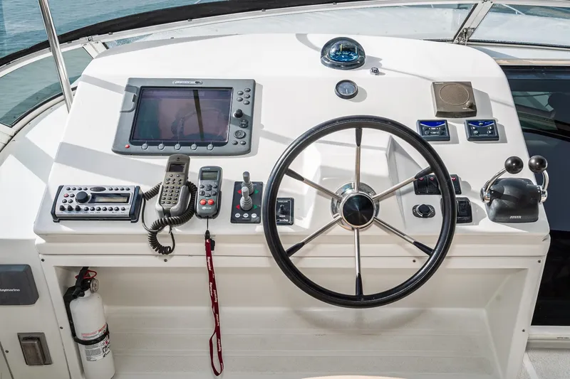 Slide: The Image of Control panel of a 2006 Navigator 5100 yacht with steering wheel and navigation equipment. - 10