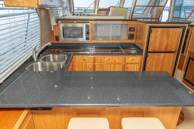Slide: The Image of Luxurious kitchen interior of 2006 Navigator 5100 yacht with modern appliances and wood cabinetry. - 24