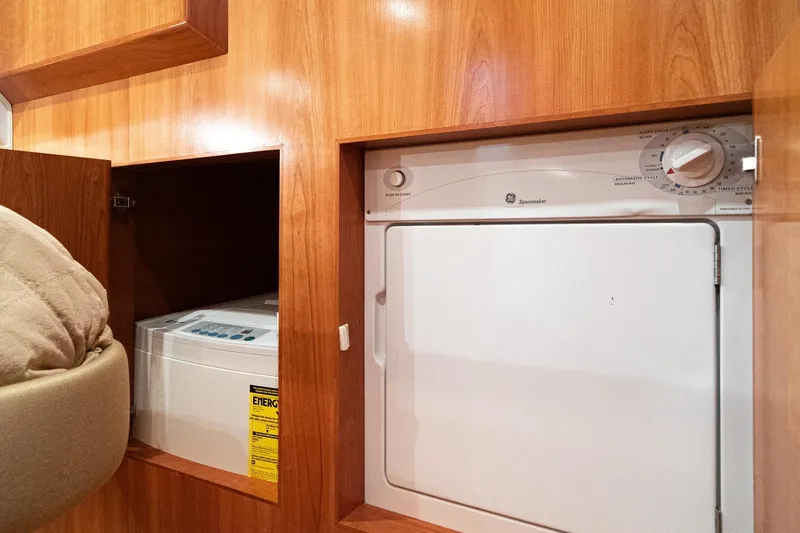Slide: The Image of 2006 Navigator 5100 RV interior with built-in washer and dryer, wooden cabinetry. - 37