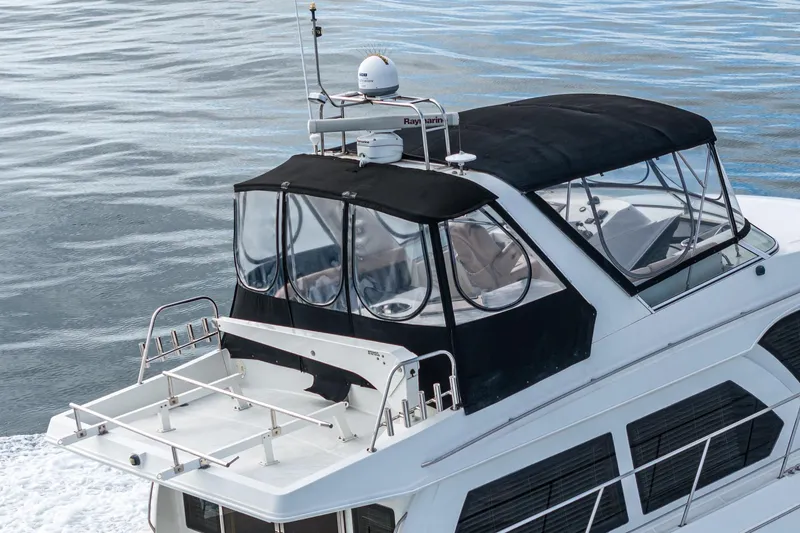 Slide: The Image of 2006 Navigator 5100 yacht with black canopy cruising on calm waters. - 4