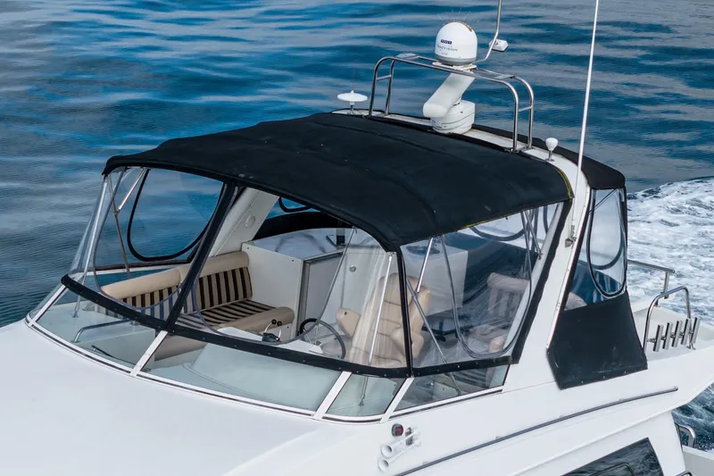 Slide: The Image of 2006 Navigator 5100 yacht with black canopy cruising on blue water. - 7