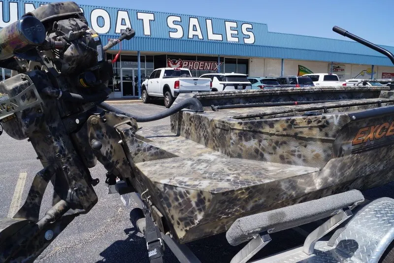 Slide: The Image of Camouflage-patterned Excel 1751 F4 boat at dealership, 2021 model, with visible outboard motor. - 13