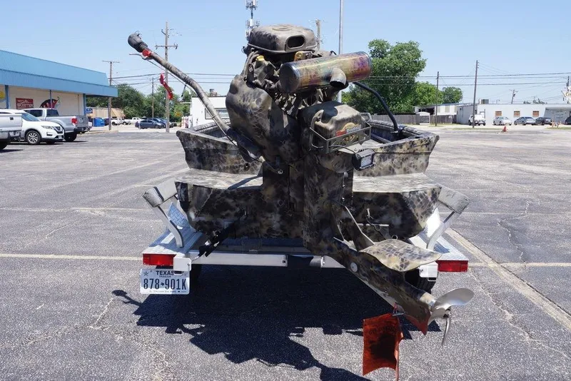 Slide: The Image of Camouflage-painted Excel 1751 F4 boat on trailer, parked in a lot, Texas license plate visible. - 15