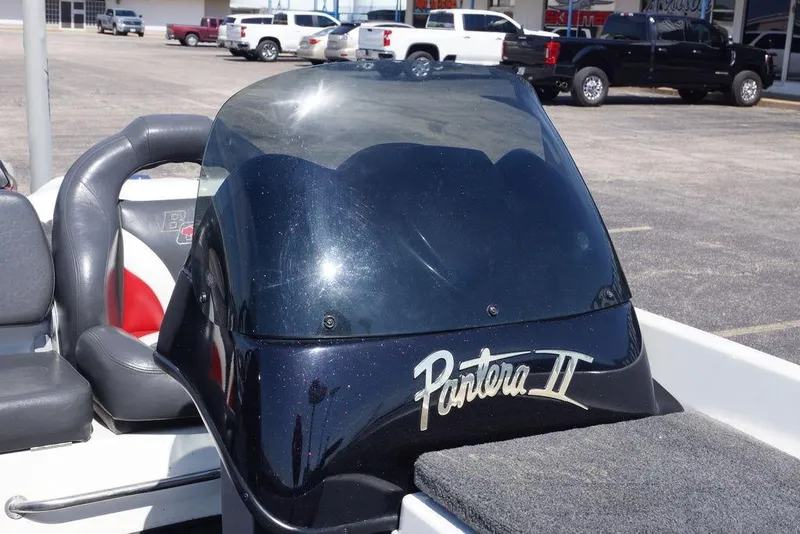 Slide: The Image of 2011 Bass Cat Pantera II boat with windshield and seating in a parking lot. - 13