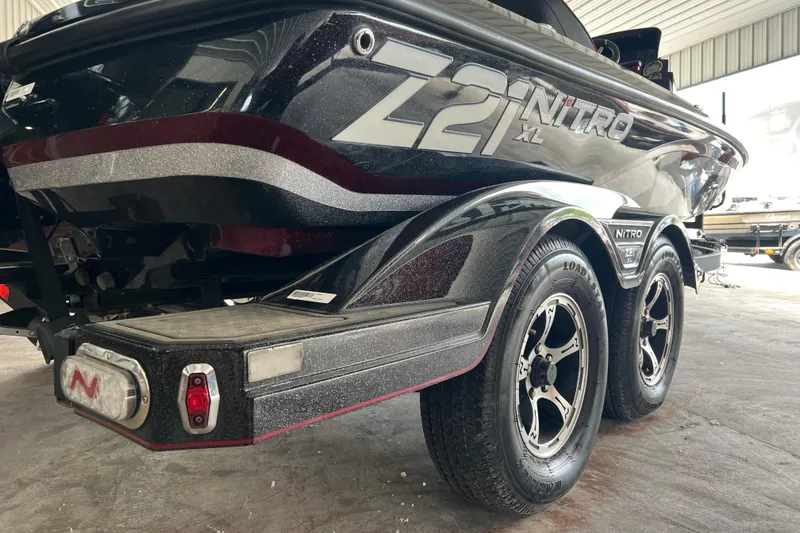 Slide: The Image of 2024 Nitro Z21 XL Pro boat on trailer, showcasing sleek design and dual wheels. - 6