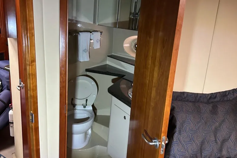 Slide: The Image of 2006 Cruisers Yachts 460 Express bathroom with wooden door and modern fixtures. - 8