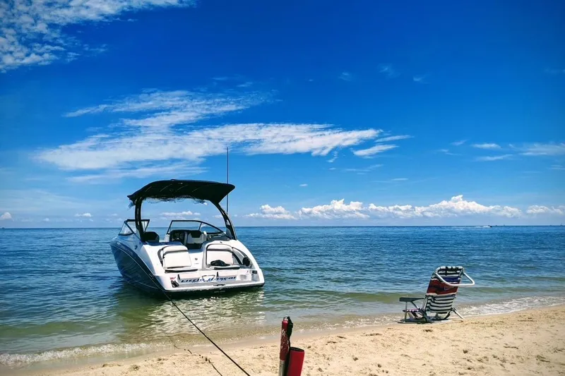 The Image of 2018 Yamaha Boats 242 Limited S E-Series anchored on a sunny beach with a chair. - 0