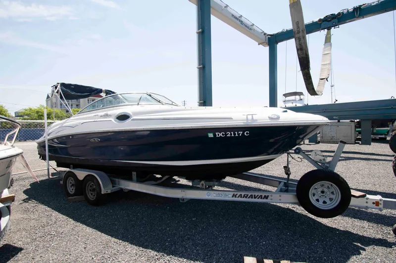 The Image of 2005 Sea Ray 240 Sundeck boat on Karavan trailer in marina setting. - 0