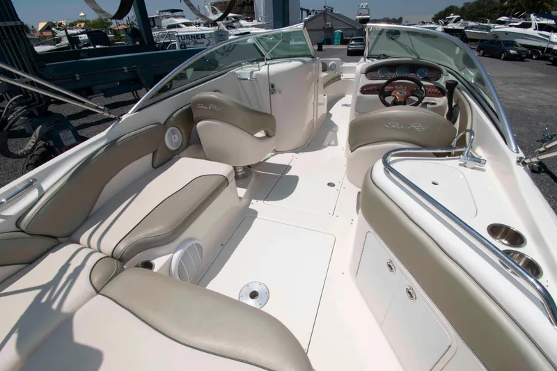 Slide: The Image of 2005 Sea Ray 240 Sundeck interior with beige seating and steering console. - 3