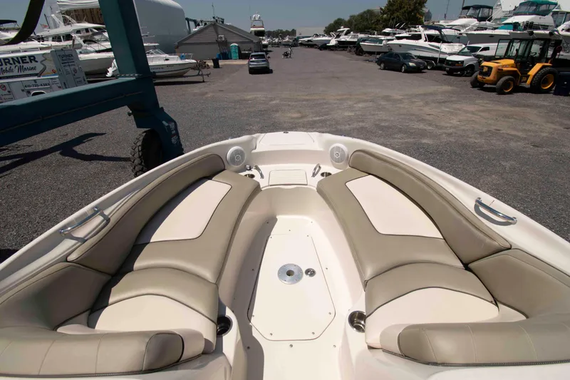Slide: The Image of 2005 Sea Ray 240 Sundeck boat interior with beige seating at a marina. - 4