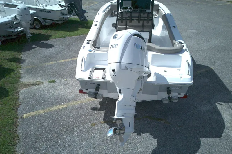 Slide: The Image of 2026 Sea Hunt Ultra 219 boat with Yamaha outboard motor, parked on pavement. - 11