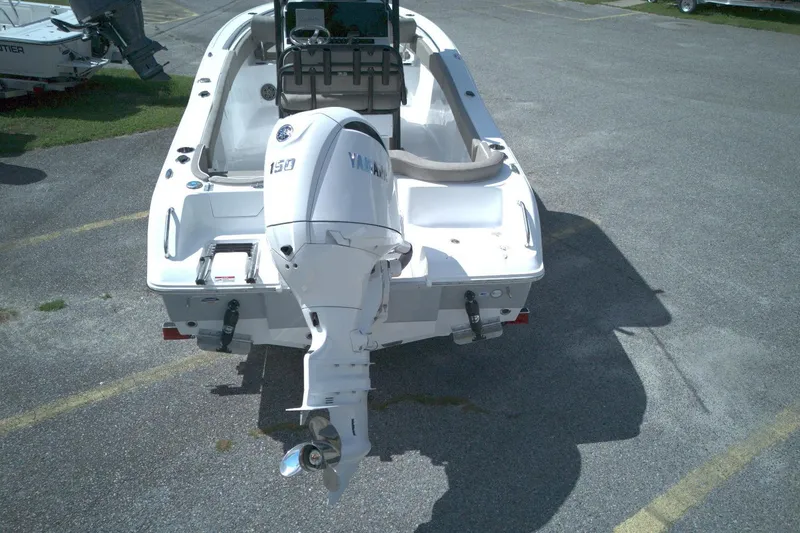 Slide: The Image of 2026 Sea Hunt Ultra 219 boat with Yamaha 150 outboard motor, parked on asphalt. - 12