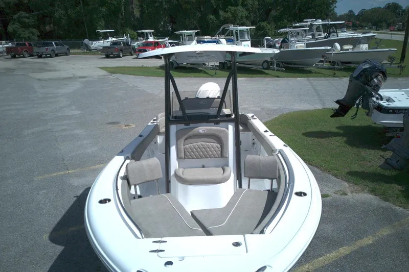 Slide: The Image of 2026 Sea Hunt Ultra 219 boat with seating, parked in a marina with other boats. - 13