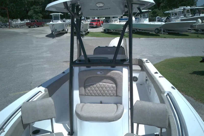 Slide: The Image of 2026 Sea Hunt Ultra 219 boat interior with seating and console, parked in a marina. - 4