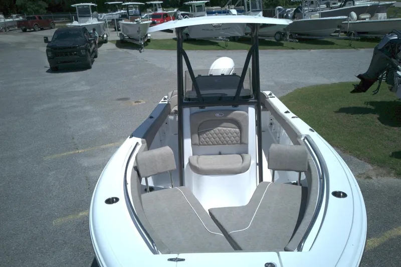 Slide: The Image of 2026 Sea Hunt Ultra 219 boat with spacious seating, parked in a marina. - 9