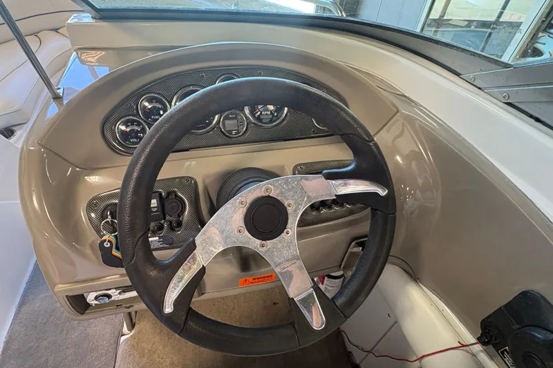 Slide: The Image of Steering wheel and dashboard of 2008 Crownline 210 LS boat, featuring gauges and controls. - 13