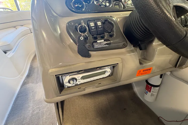 Slide: The Image of 2008 Crownline 210 LS boat dashboard with controls, stereo, and warning label. - 14