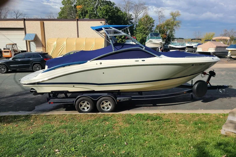 Slide: The Image of 2009 Bryant 268 boat on trailer, parked outdoors near other boats. - 12