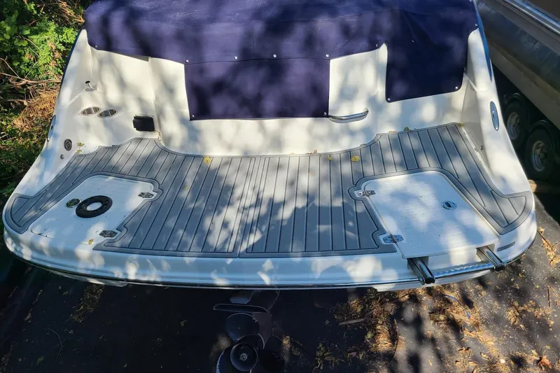 Slide: The Image of Rear view of a 2009 Bryant 268 boat with a spacious deck and blue cover. - 17